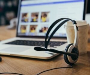 Headset on a desk next to a laptop and coffee cup, symbolizing customer support for Pure Broadband MI's internet services.